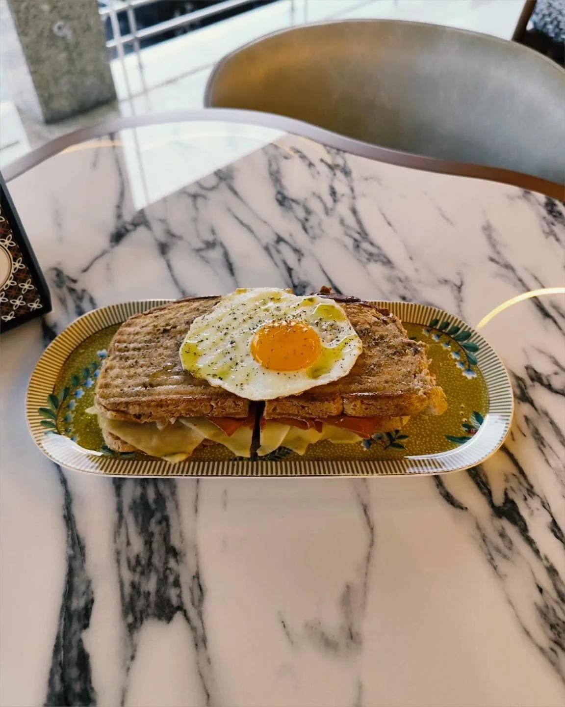 Tosta com ovo servida em mesa de mármore
